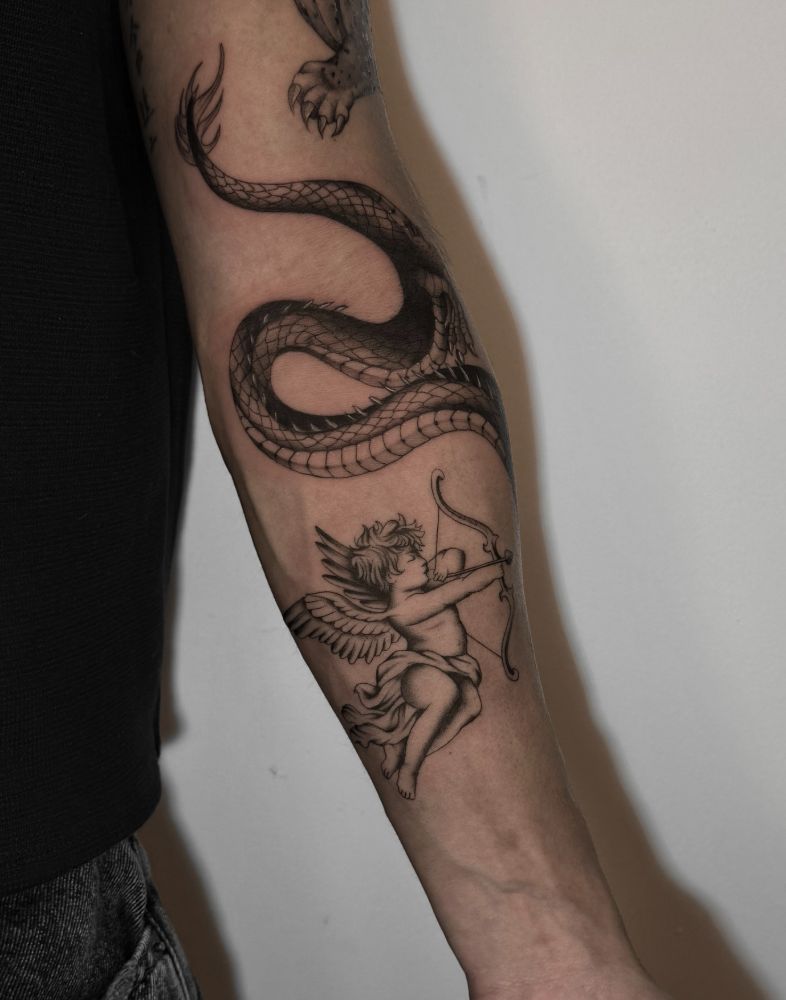 Tatuagem de serpente e cupido com arco e flecha, no braço.