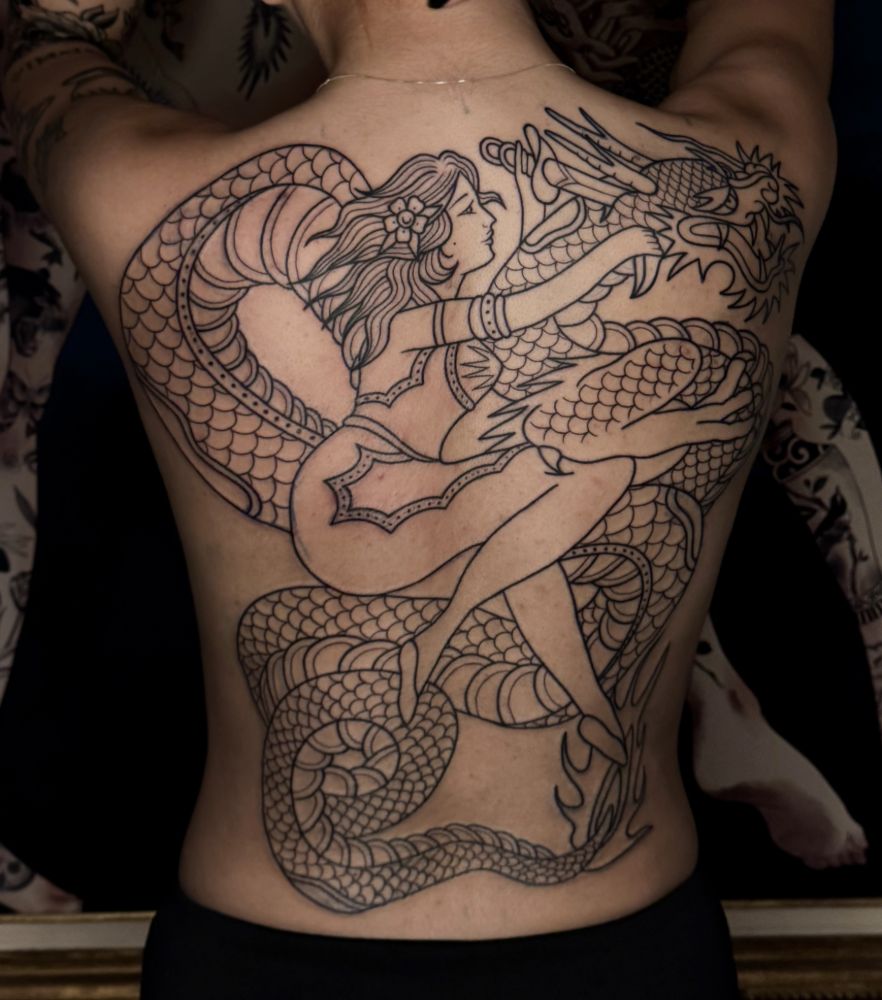 Tatuagem fechando as costas, com sereia e dragão em traço fino.